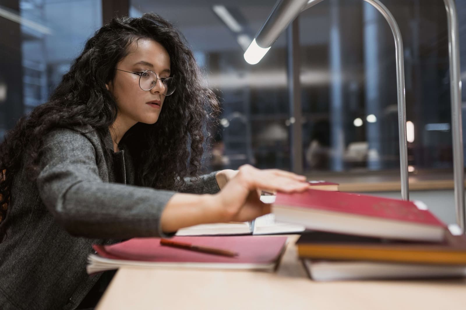 Student sorting through reports and reference books at a desk